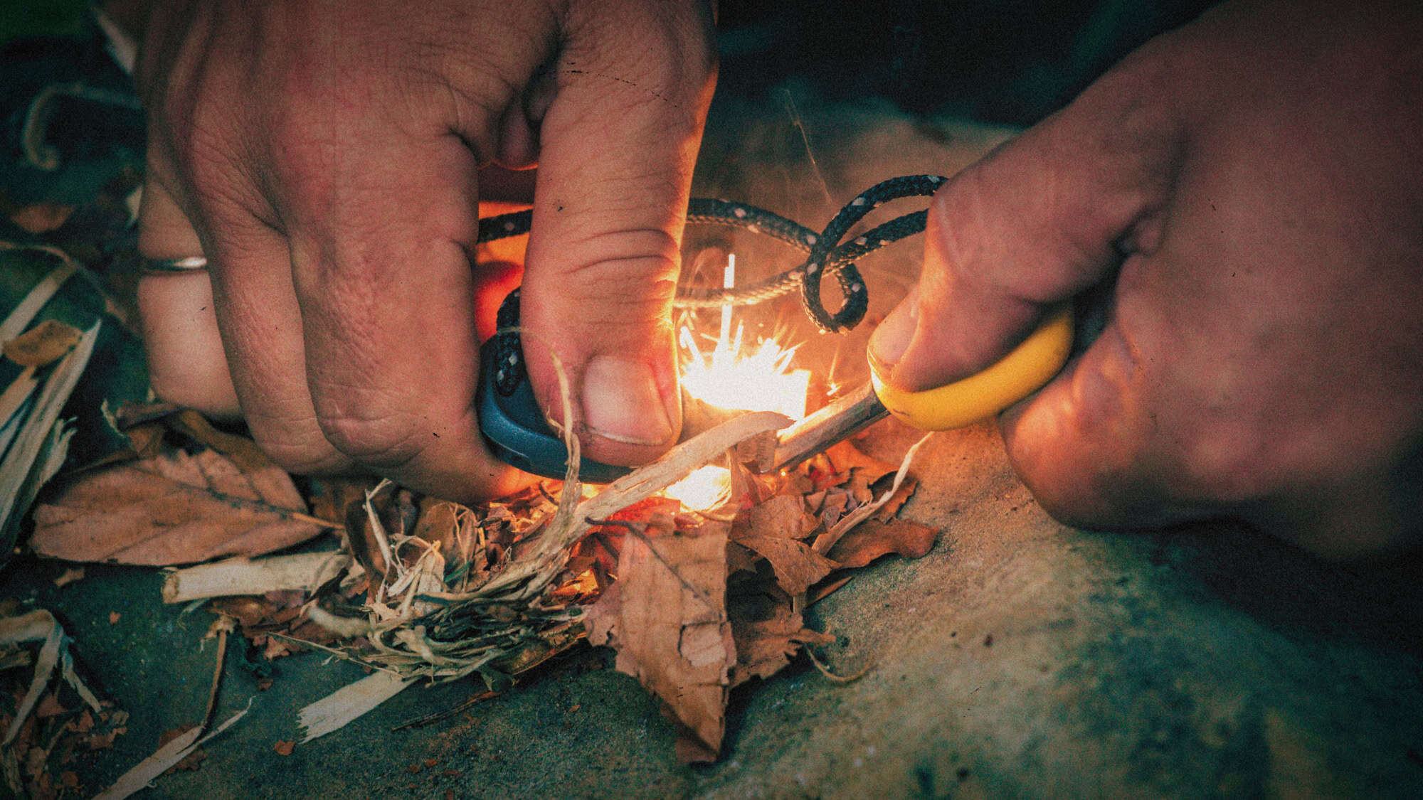 Beste noodpakketten - twee handen die vuur maken met een vuurstick