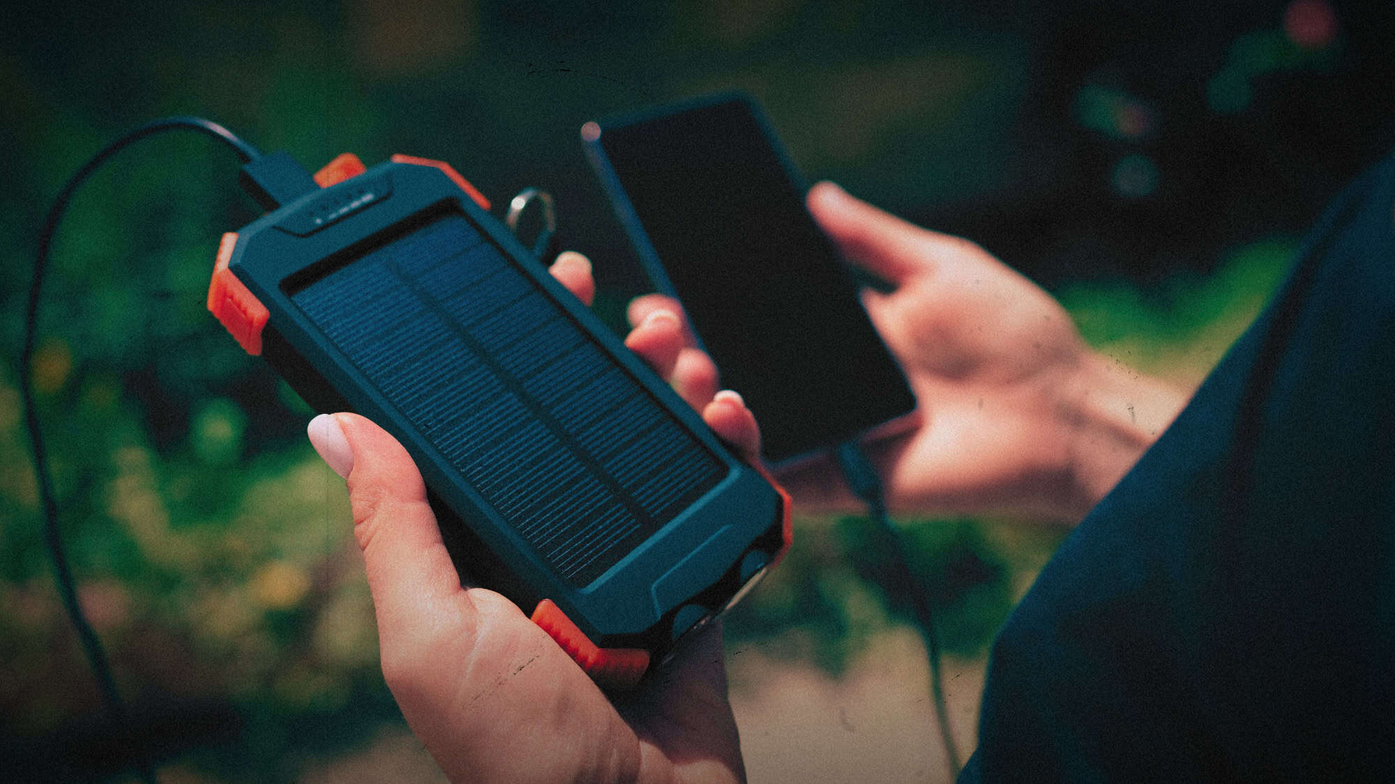 Beste solar powerbanks - iemand die een solar powerbank en een telefoon vasthoudt