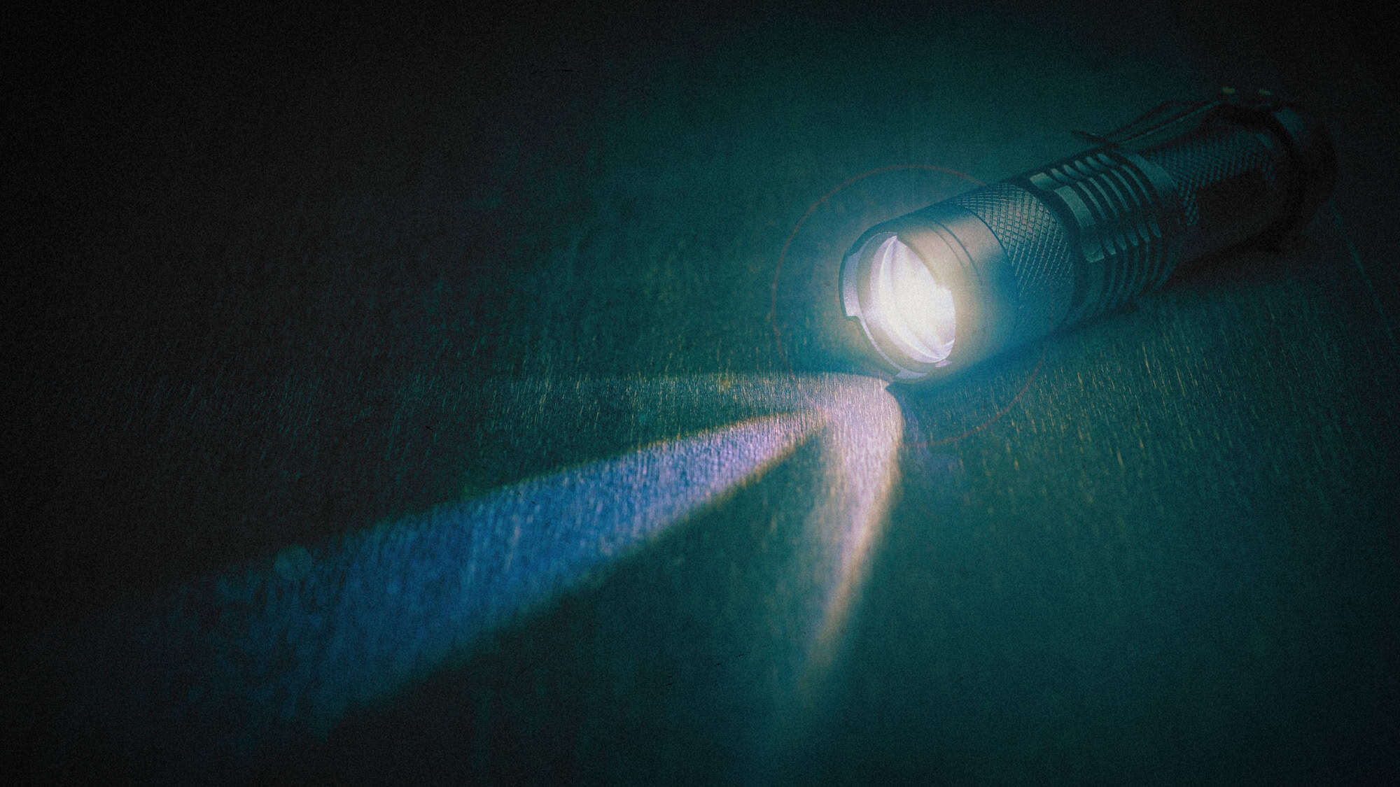 Beste zaklampen op batterijen - een schijnende zaklamp in het donker op tafel